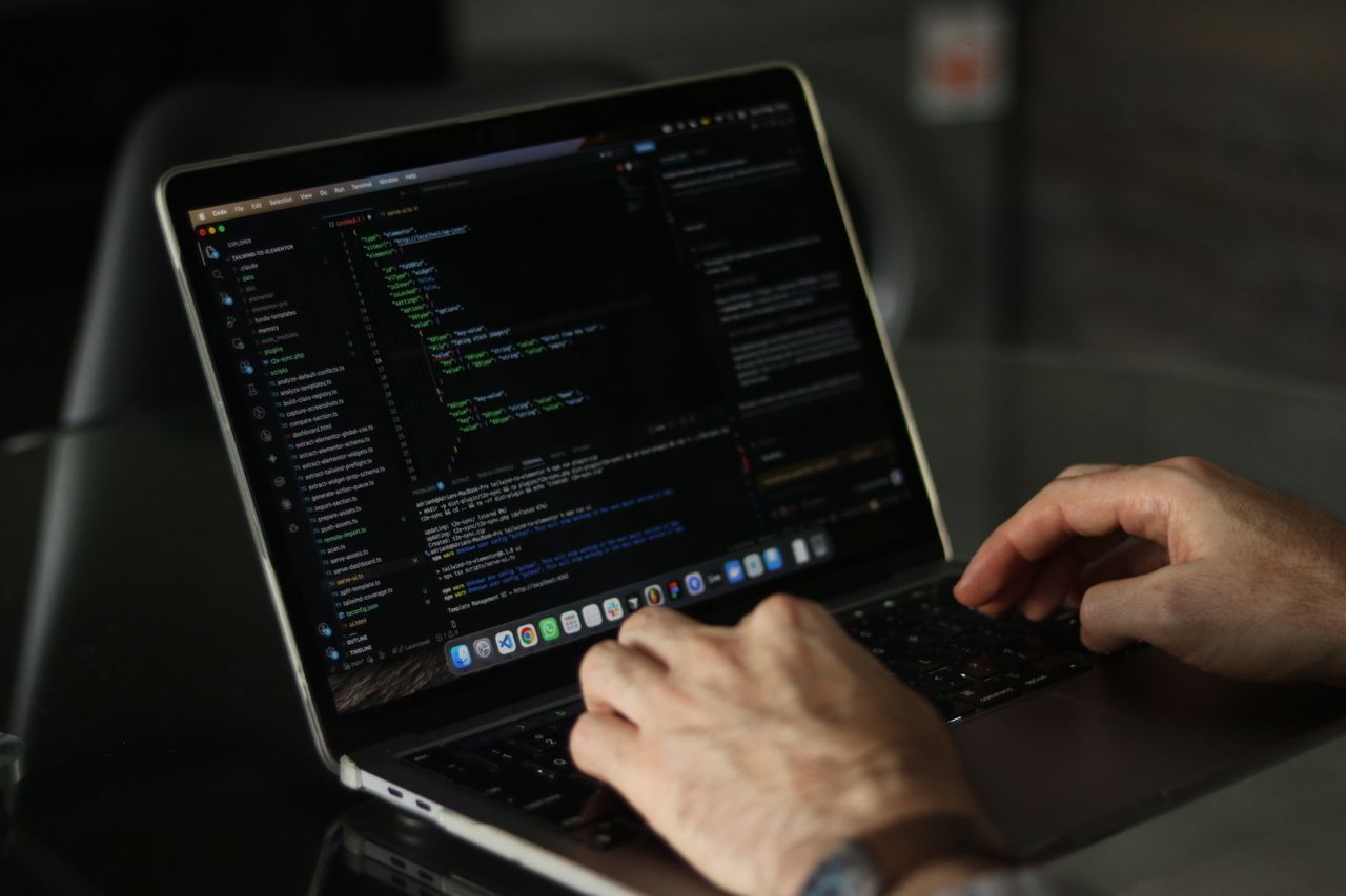 Close-up of hands coding on a laptop, focusing on programming productivity.